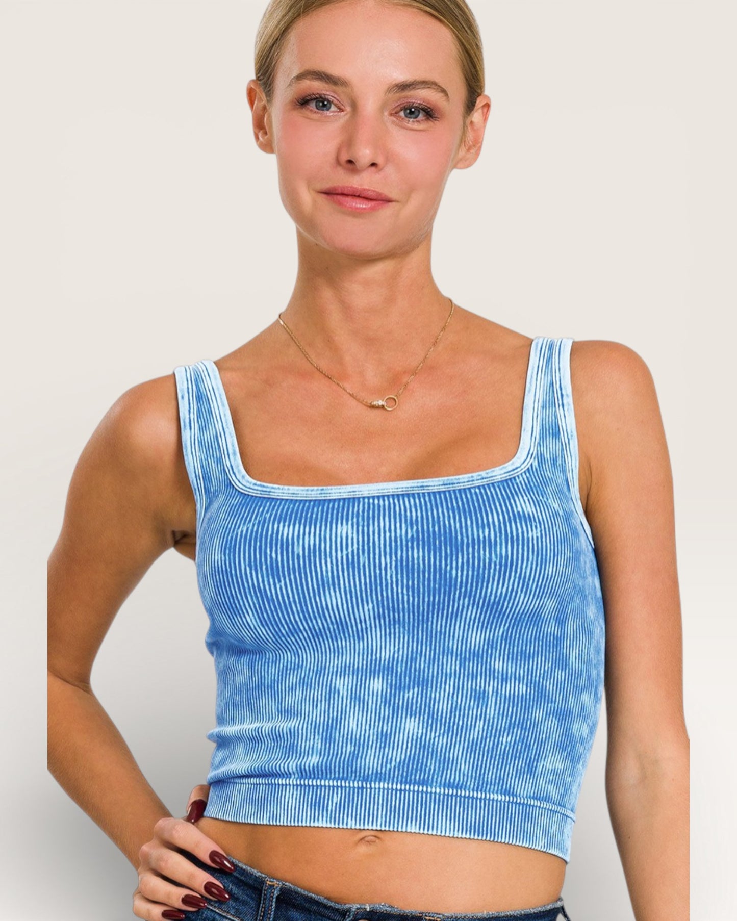 Woman wearing a blue tie-dye tank top against a plain background
