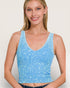 Woman wearing a blue tank top against a plain background