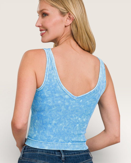 Woman wearing a blue tank top with a plain background