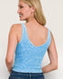Woman wearing a blue tank top with a plain background