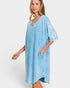 Woman wearing a light blue oversized dress on a white background