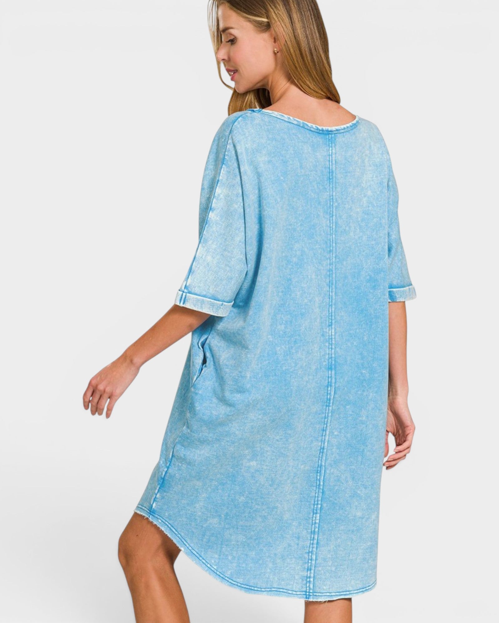 Woman wearing a light blue denim dress on a white background