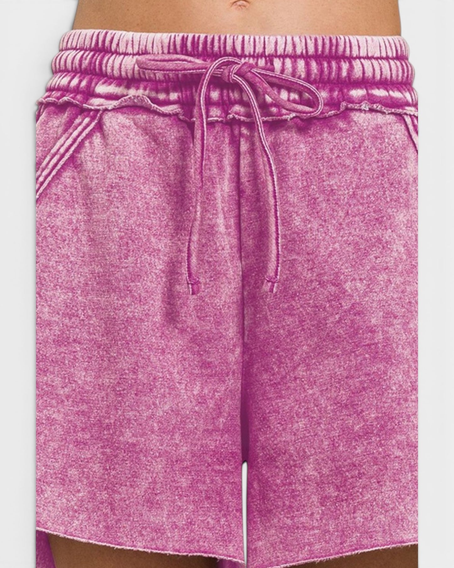 Pink shorts with a drawstring on a white background