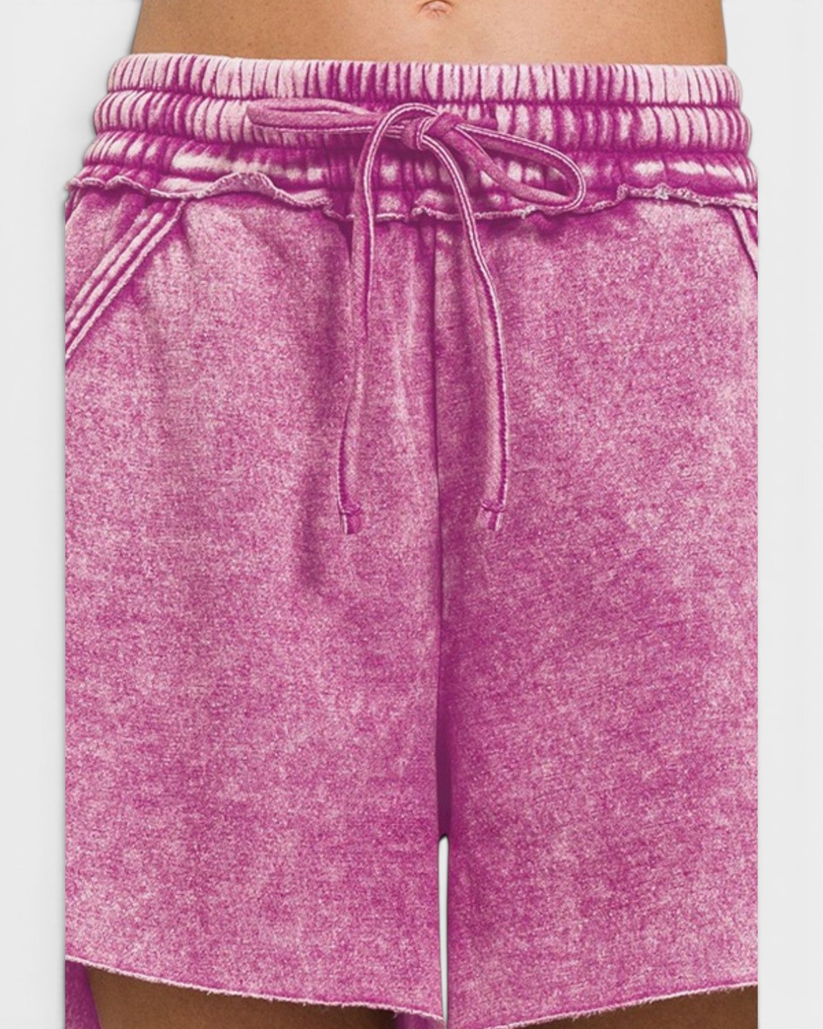 Pink shorts with a drawstring on a white background