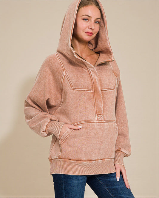 Woman wearing a brown hoodie against a beige background