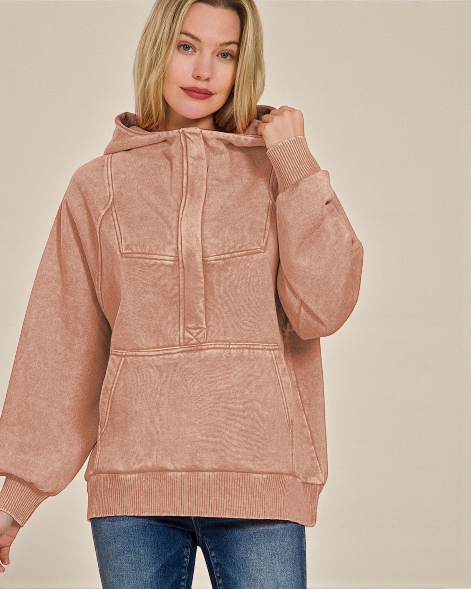 Woman wearing a pink hoodie against a beige background