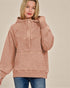 Woman wearing a pink hoodie against a beige background