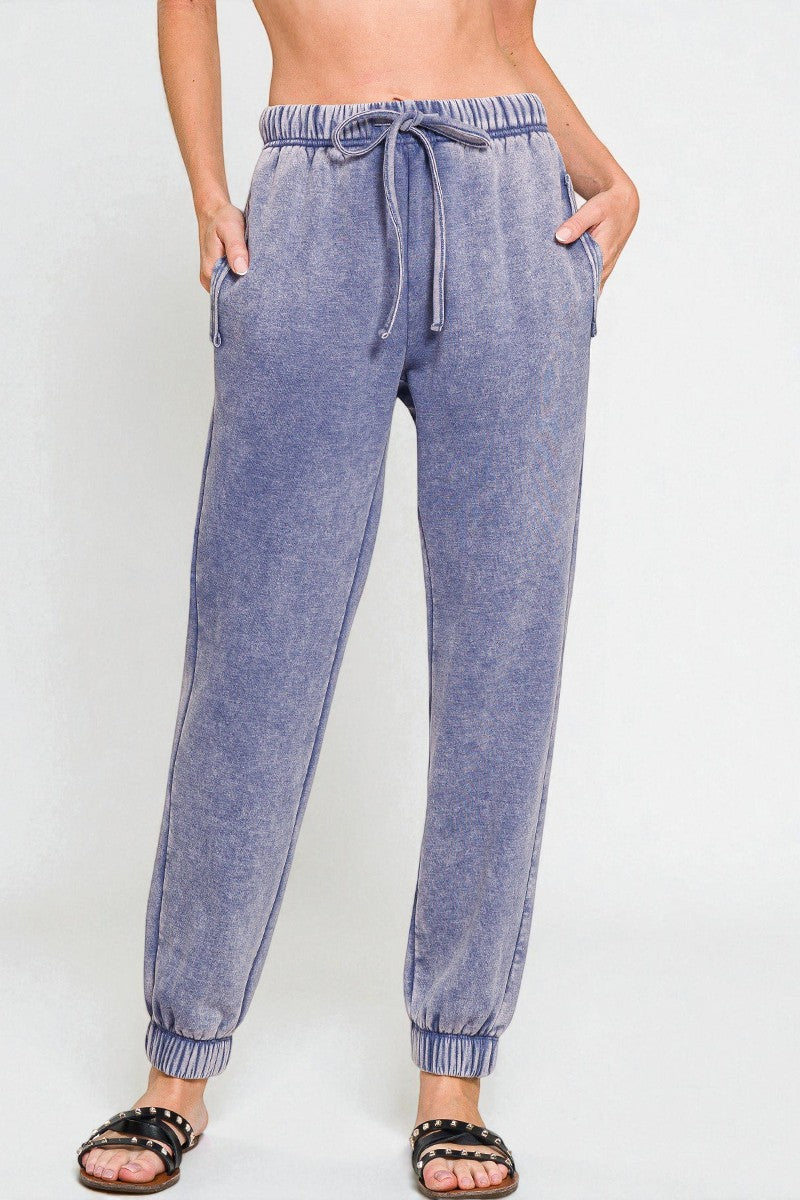 Blue jogger pants worn by a person on a white background