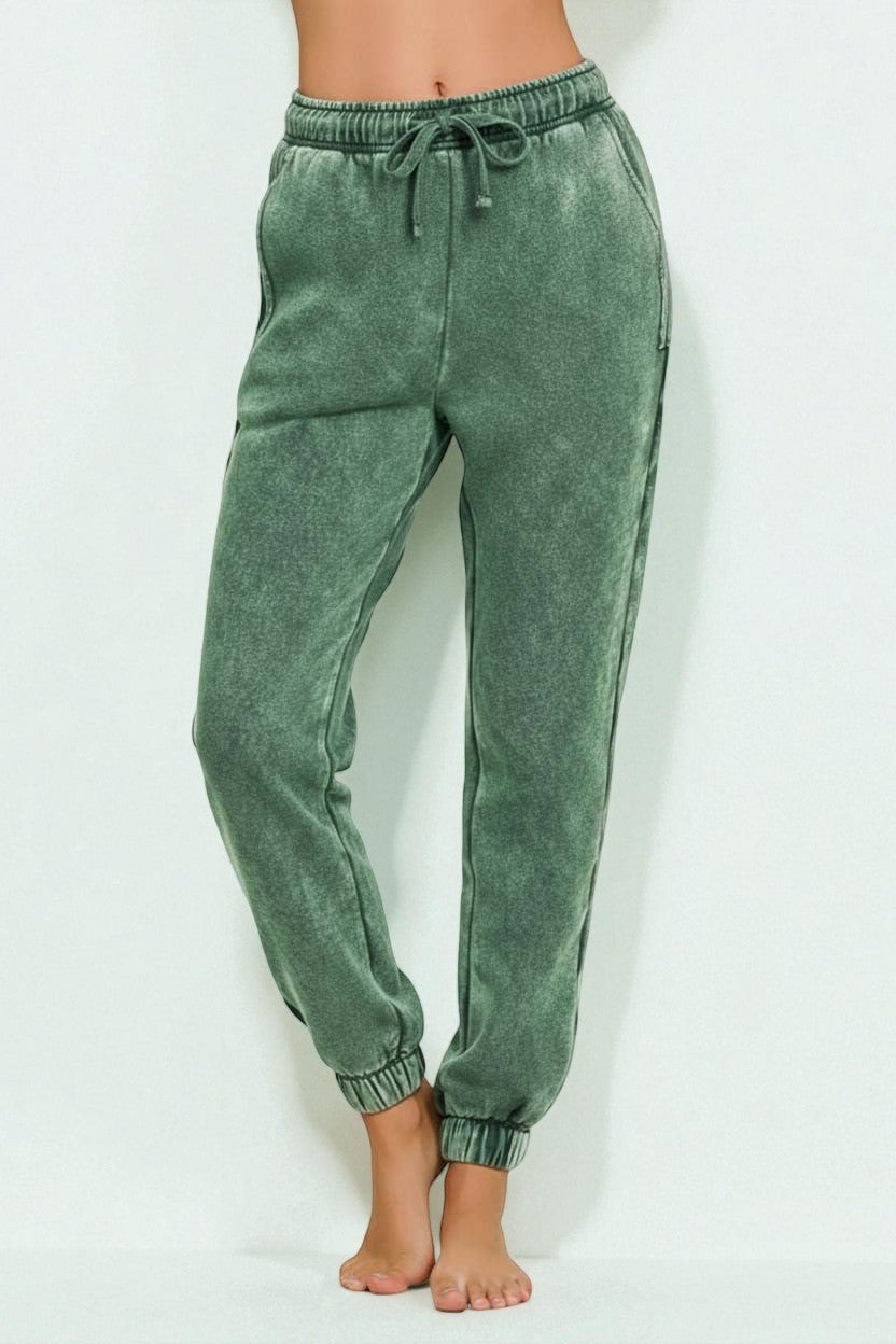 Green acid-wash jogger pants on a white background