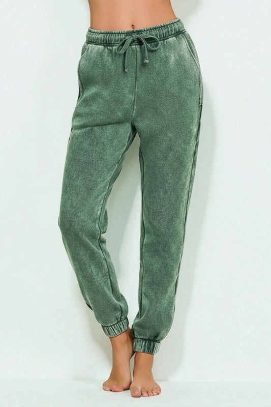 Green acid-wash jogger pants on a white background