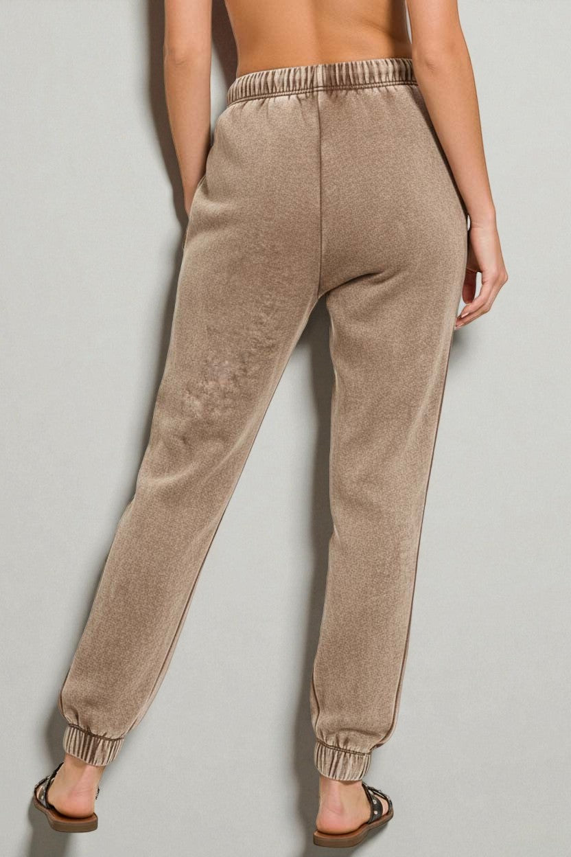 Beige sweatpants worn by a person on a plain background
