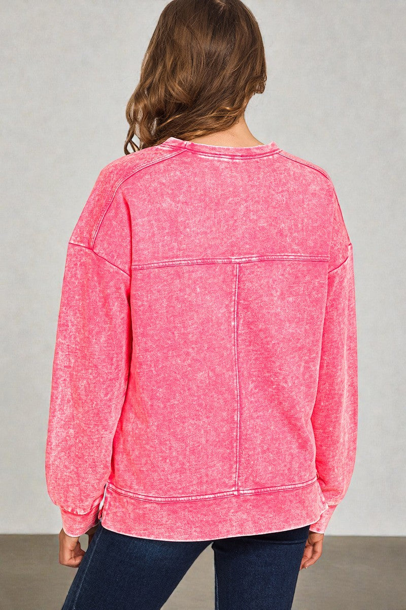 Person wearing a pink sweatshirt with a gray background