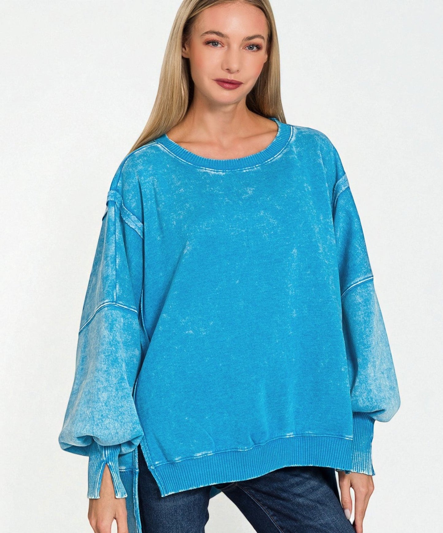Woman wearing a blue distressed sweater on a white background