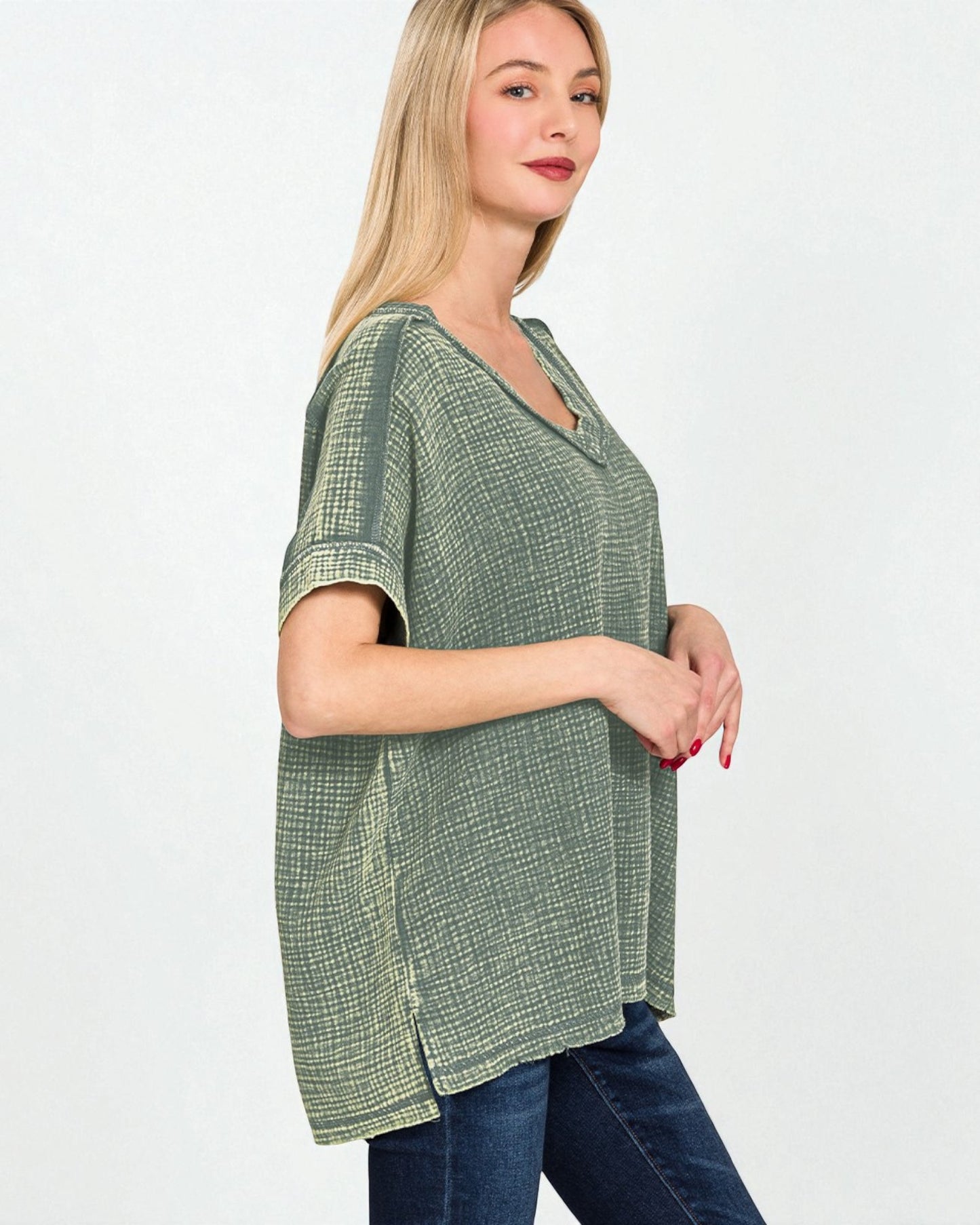 Woman wearing a green checkered top and blue jeans on a white background