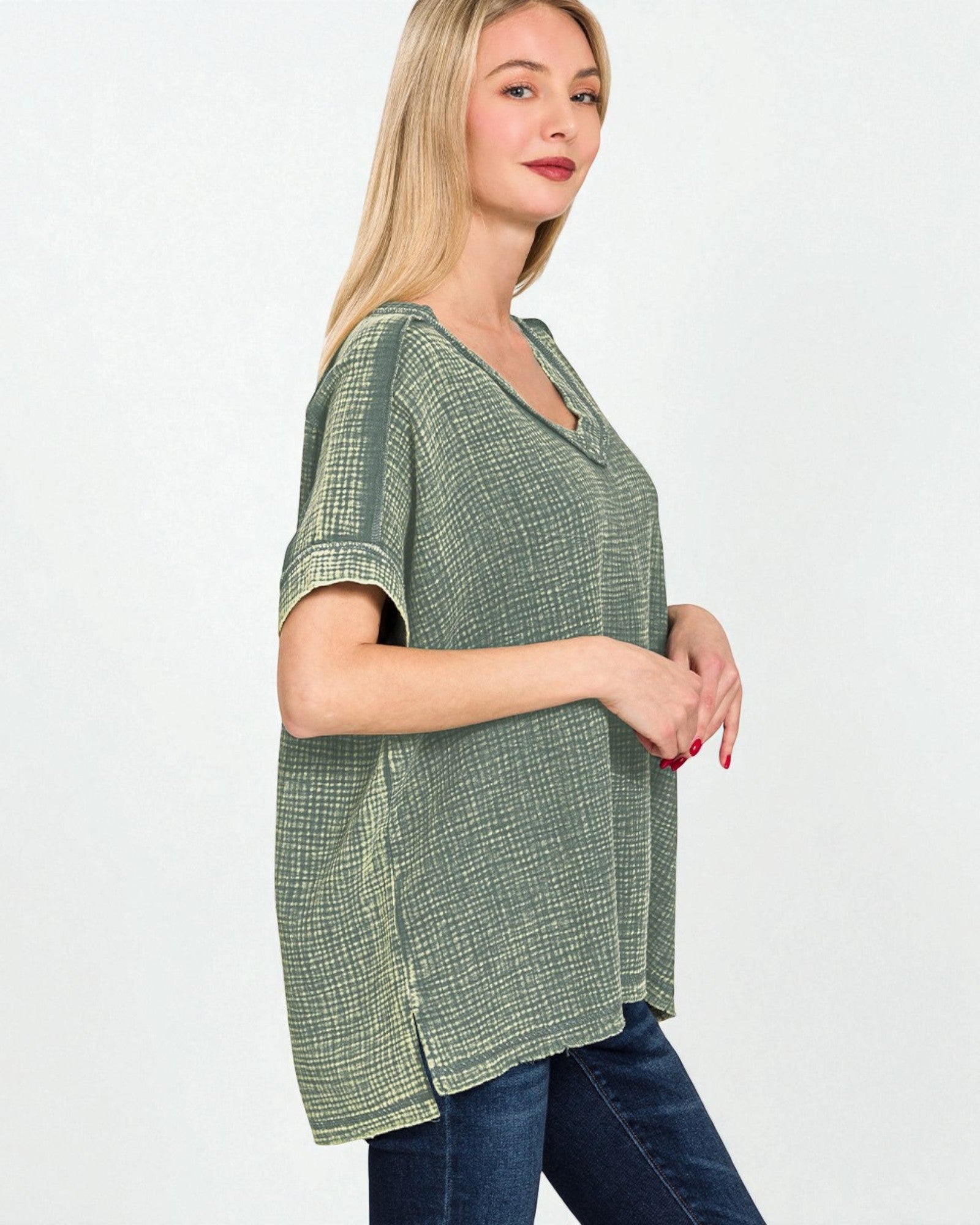 Woman wearing a green checkered top and blue jeans on a white background