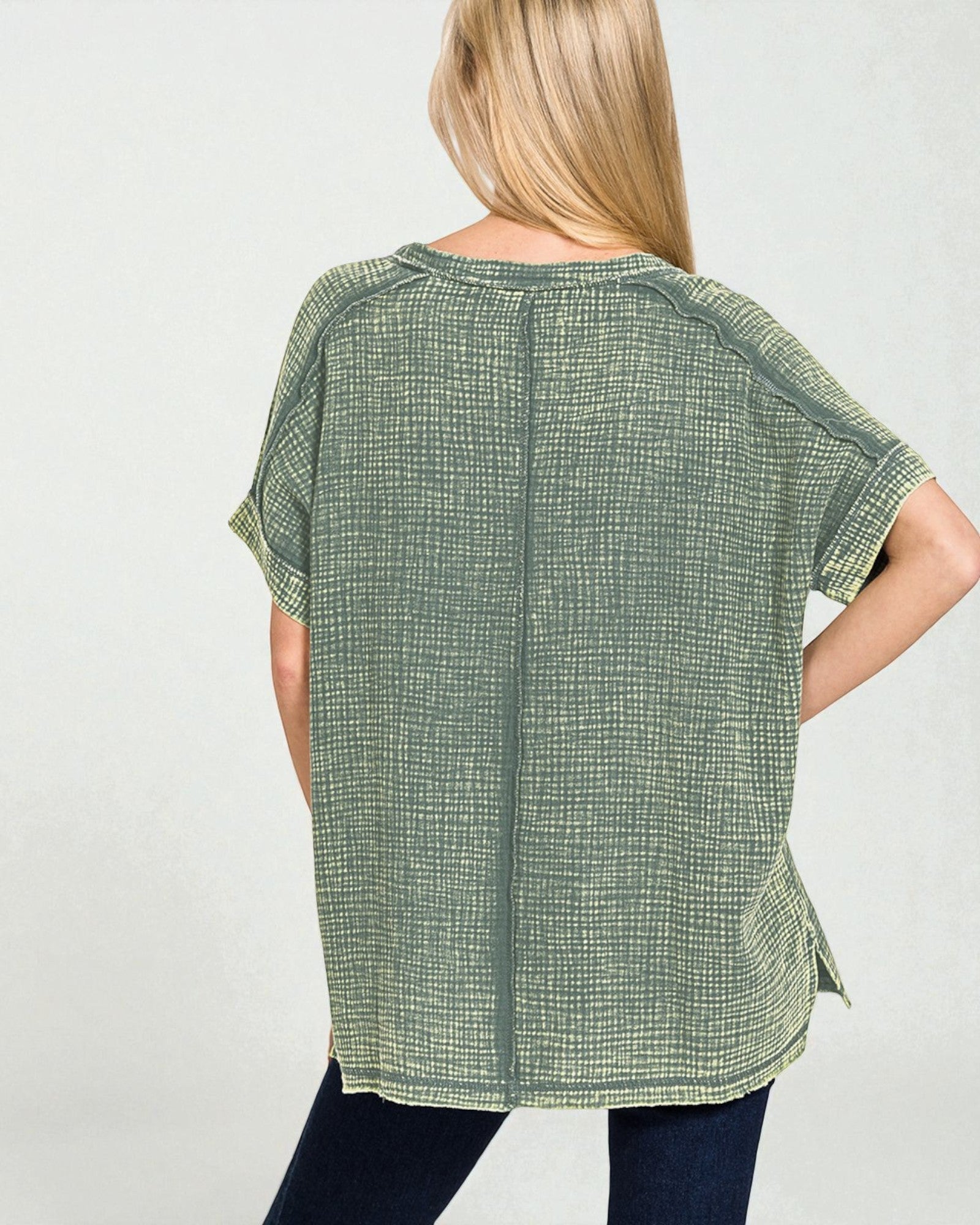 Woman wearing a green checkered top against a white background