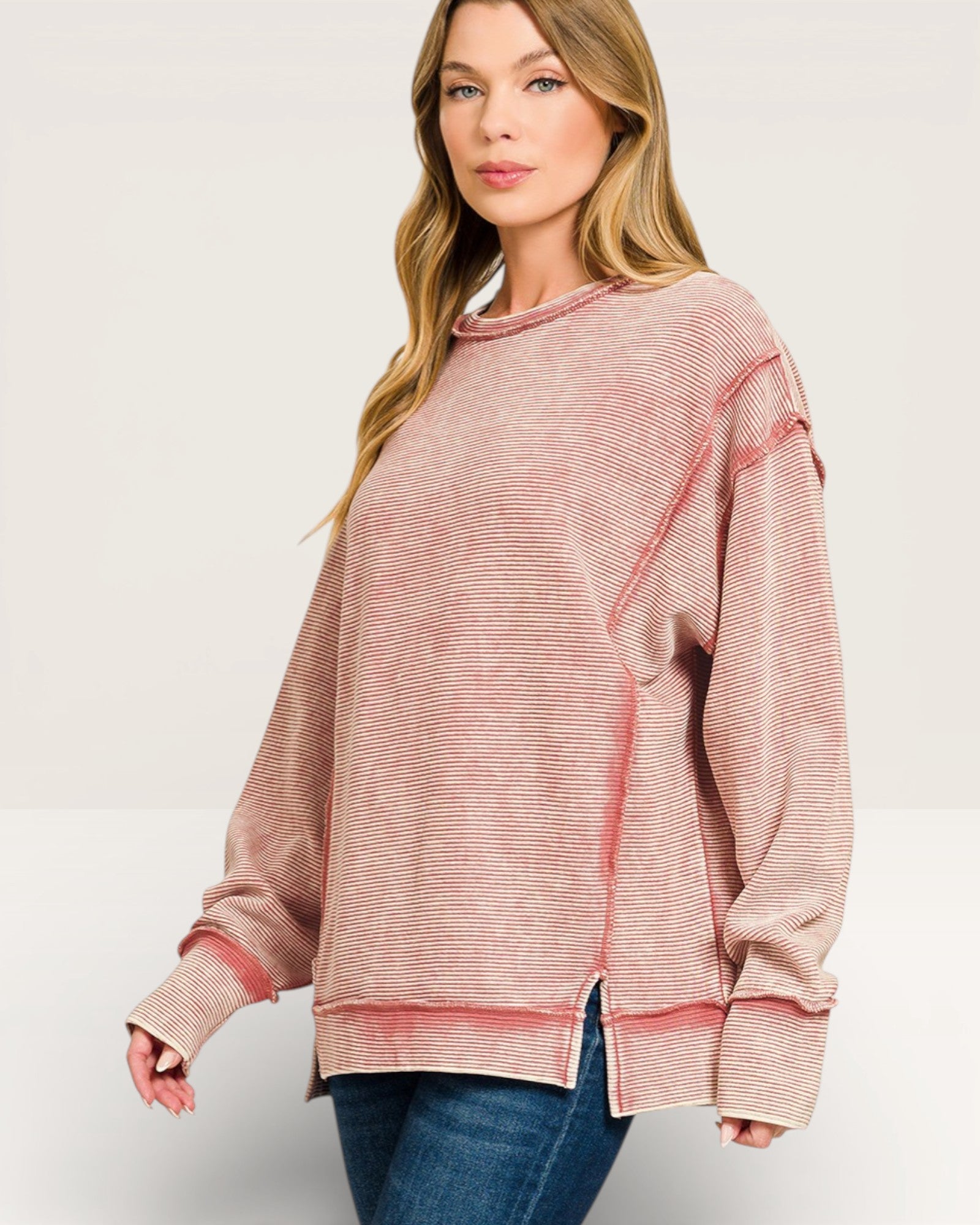 Woman wearing a pink striped sweater on a white background