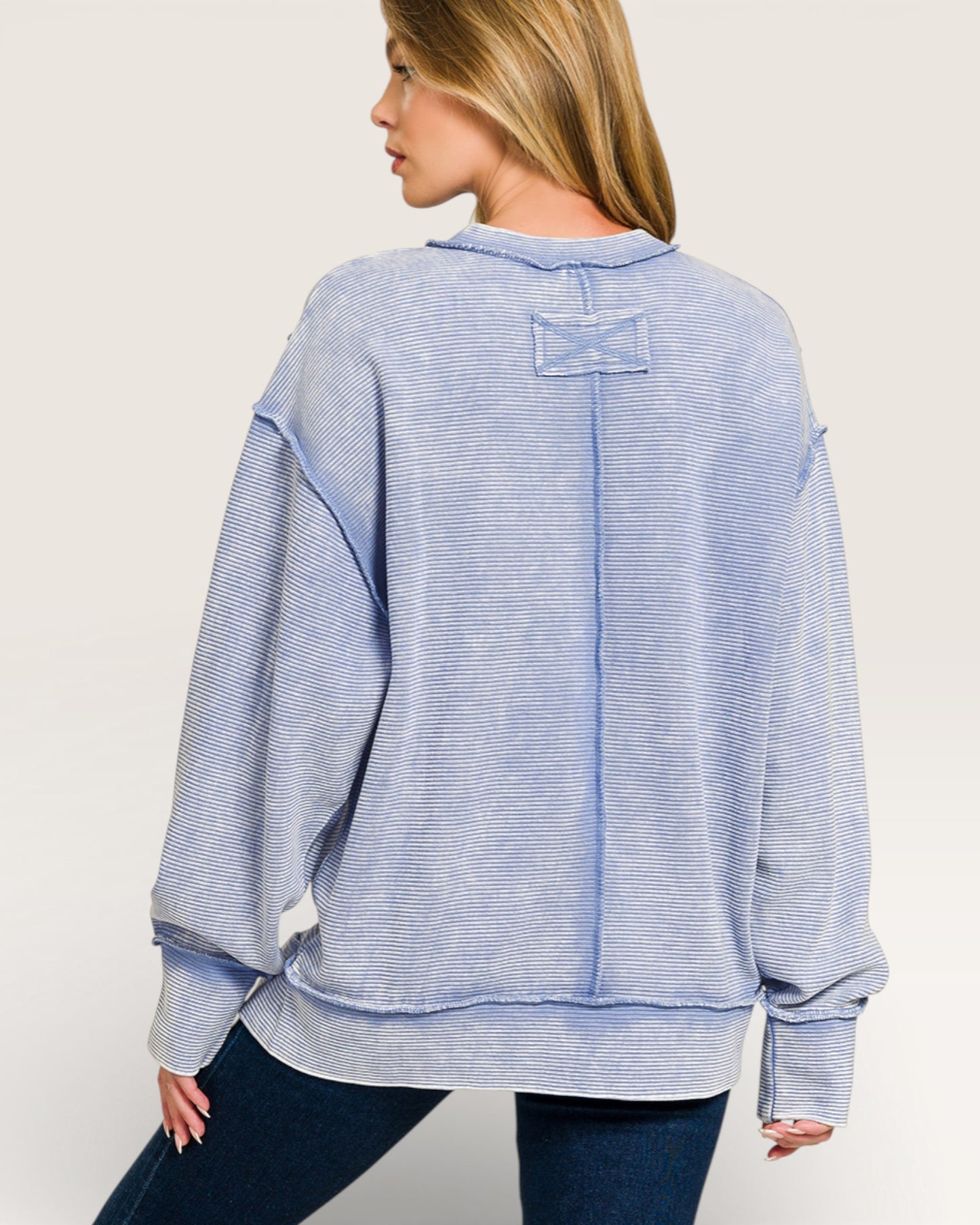 Woman wearing a blue striped sweater on a white background