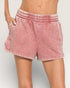 Pink shorts worn by a person on a plain background