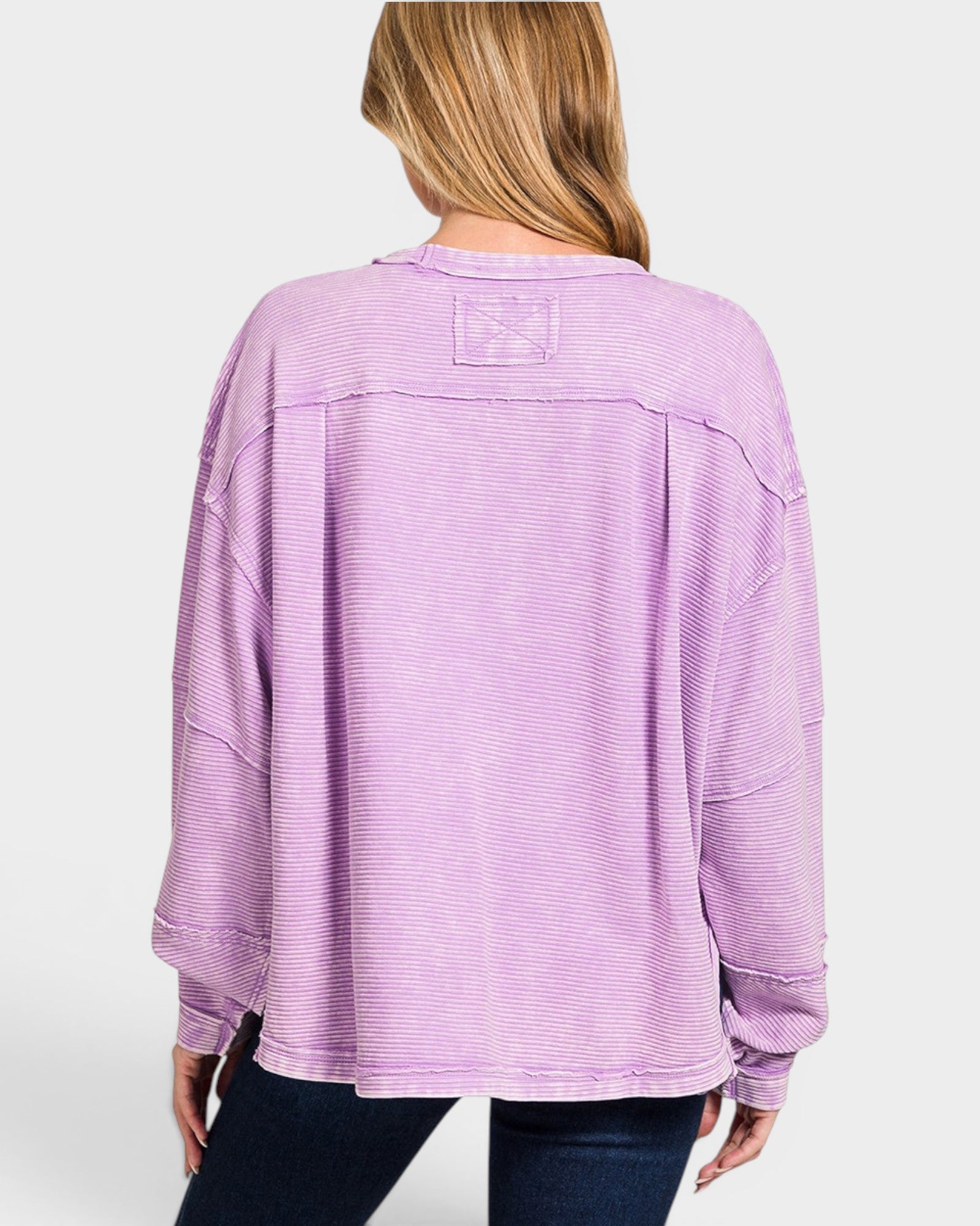 Person wearing a purple textured sweater on a white background