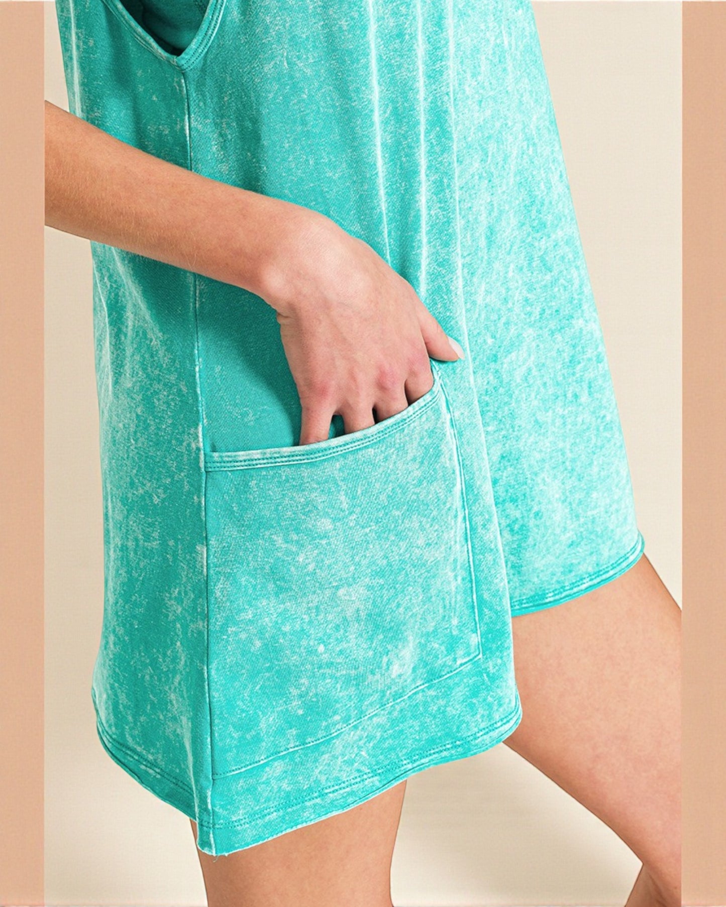 Teal dress with a pocket on a beige background
