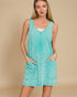 Woman wearing a turquoise sleeveless dress against a beige background
