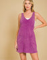 Woman wearing a purple sleeveless dress against a beige background
