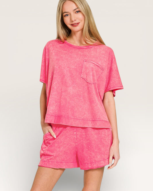 Woman wearing a pink oversized t-shirt and shorts set on a light background