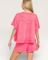 Woman wearing a pink denim outfit on a plain background