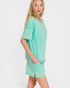Woman wearing a mint green outfit on a white background