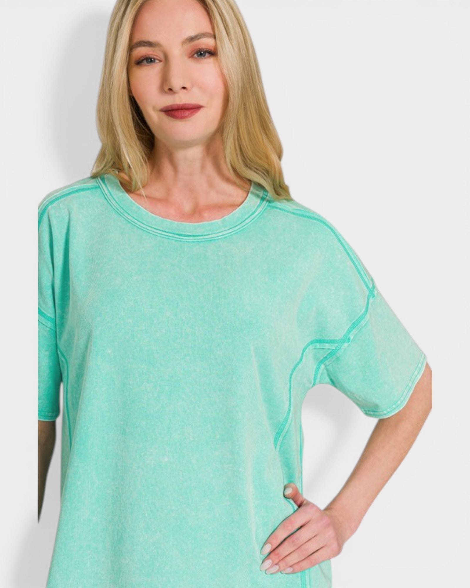 Woman wearing a teal t-shirt against a white background