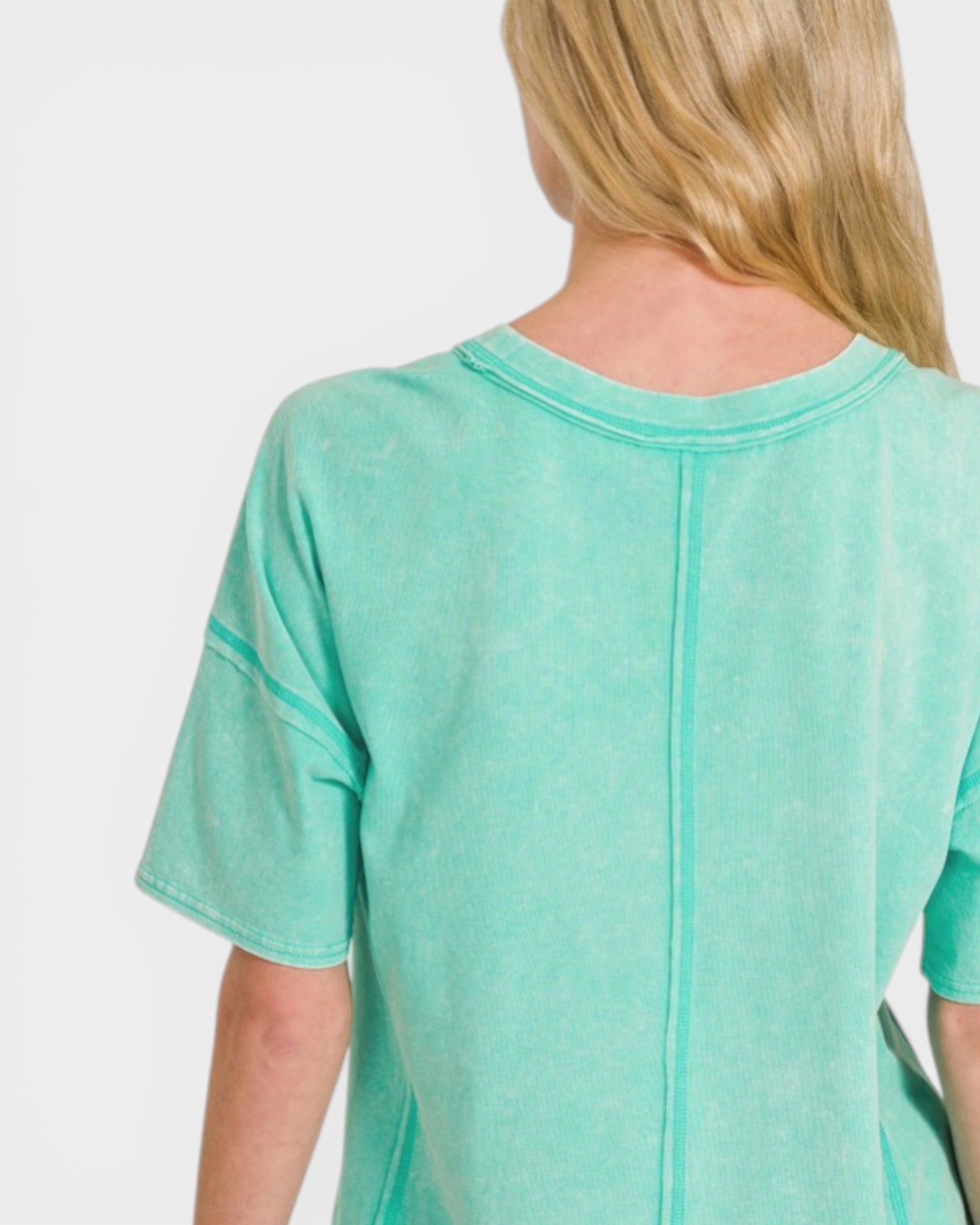 Person wearing a teal shirt on a white background