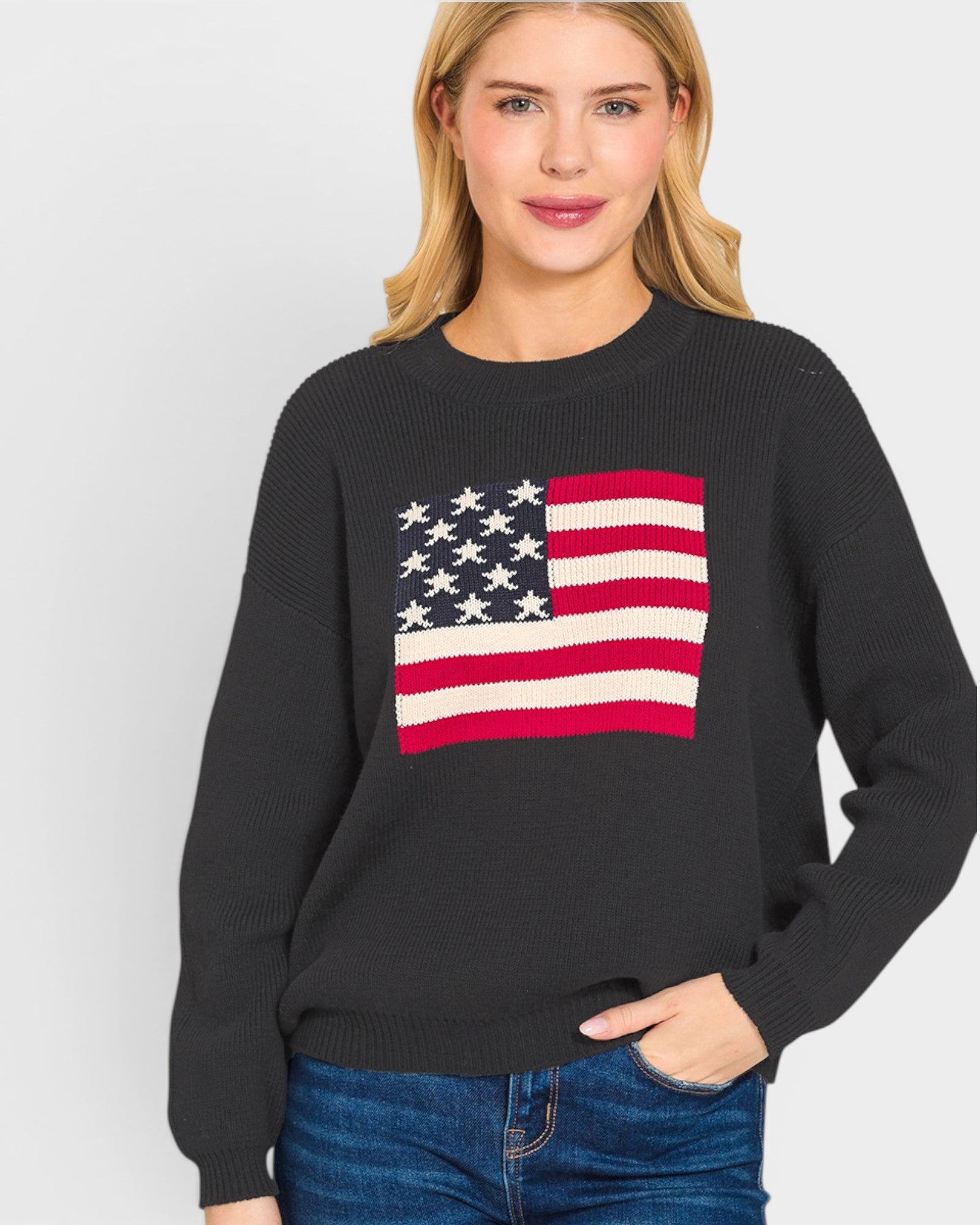 Woman wearing a black sweater with an American flag design on a white background
