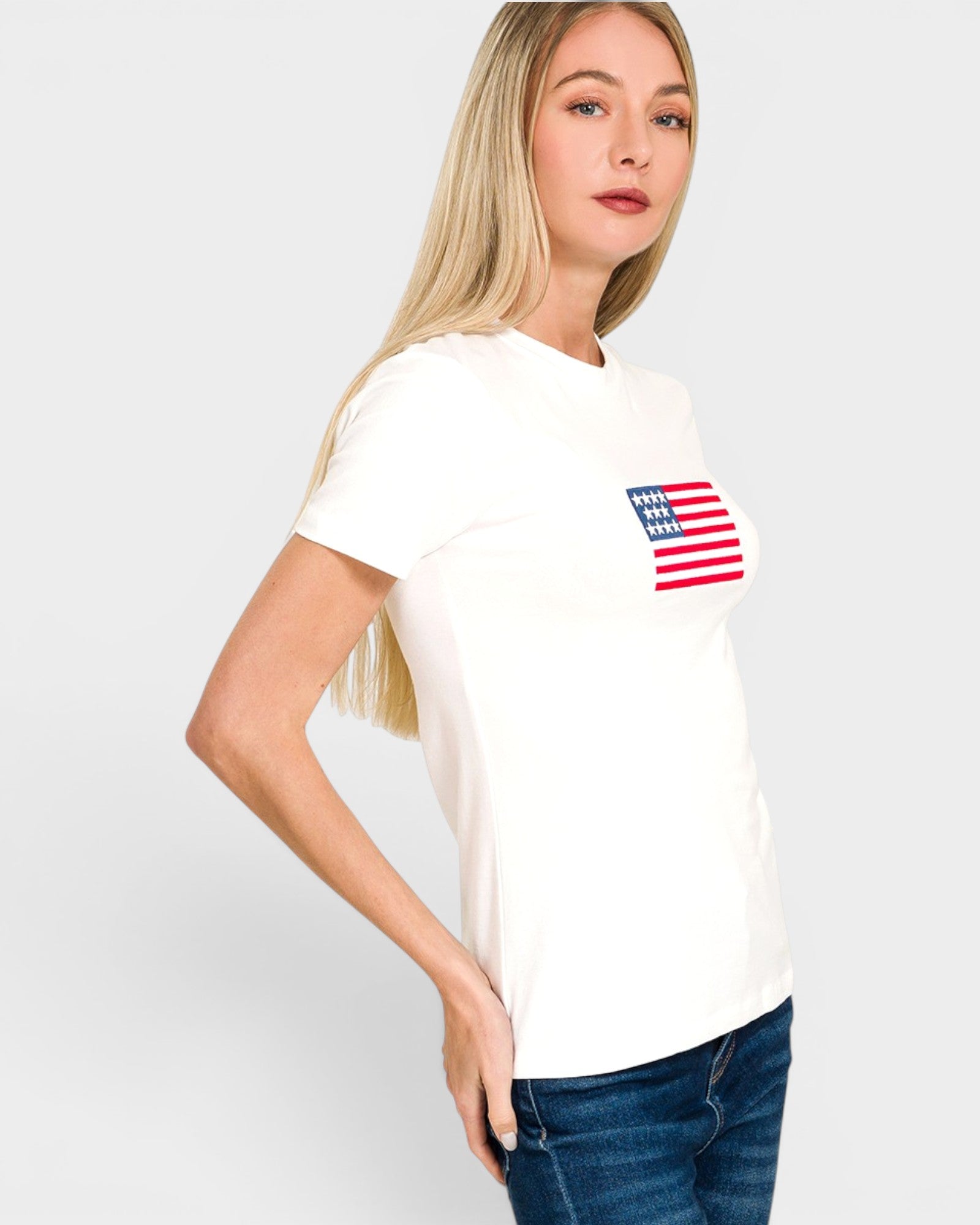 Woman wearing a white t-shirt with an American flag design on a plain background