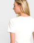 Woman wearing a plain white t-shirt against a light gray background