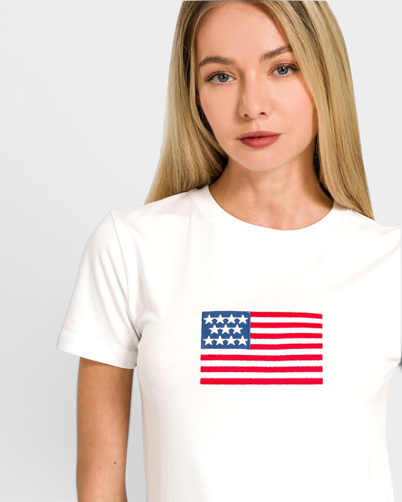 Woman wearing a white t-shirt with an American flag design on a plain background