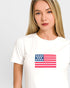 Woman wearing a white t-shirt with an American flag design on a plain background