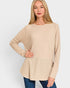 Woman wearing a beige long-sleeve top against a white background