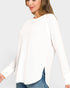 Woman wearing a white blouse with long sleeves on a plain background