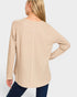 Beige long-sleeve top worn by a person on a white background
