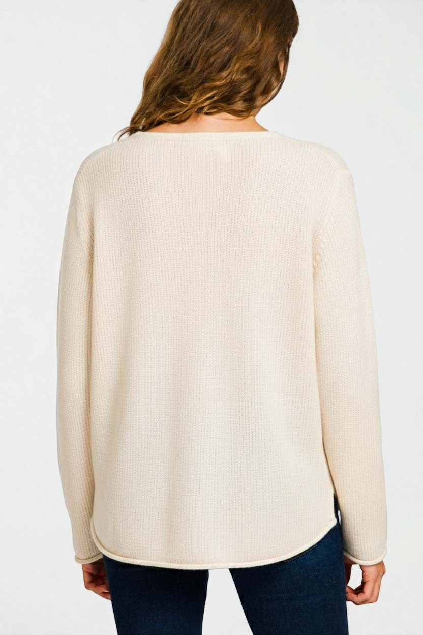 Person wearing a beige sweater on a white background