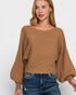 Woman wearing a brown sweater and blue jeans on a white background