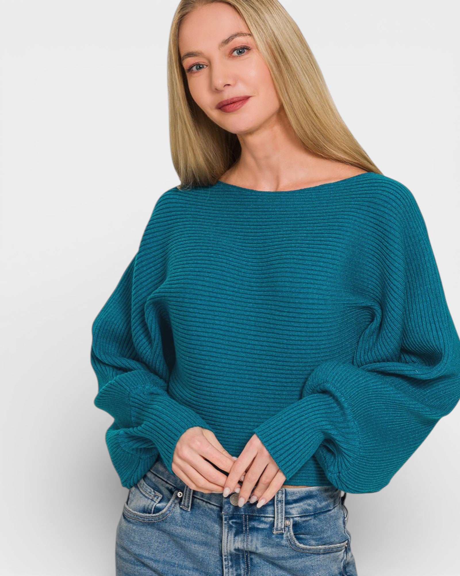 Woman wearing a teal sweater against a white background