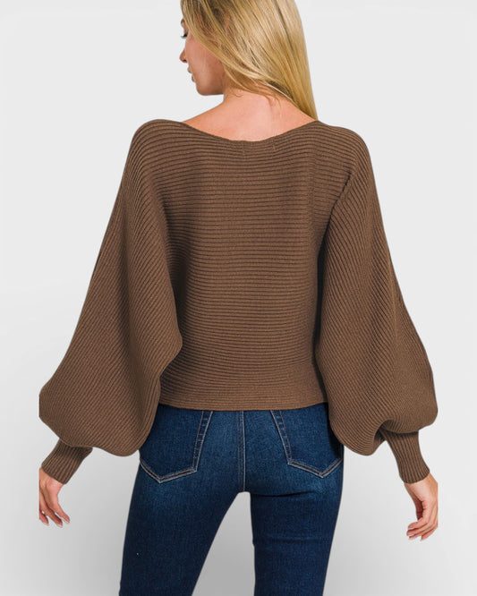 Woman wearing a brown sweater with balloon sleeves on a white background