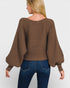 Woman wearing a brown sweater with balloon sleeves on a white background