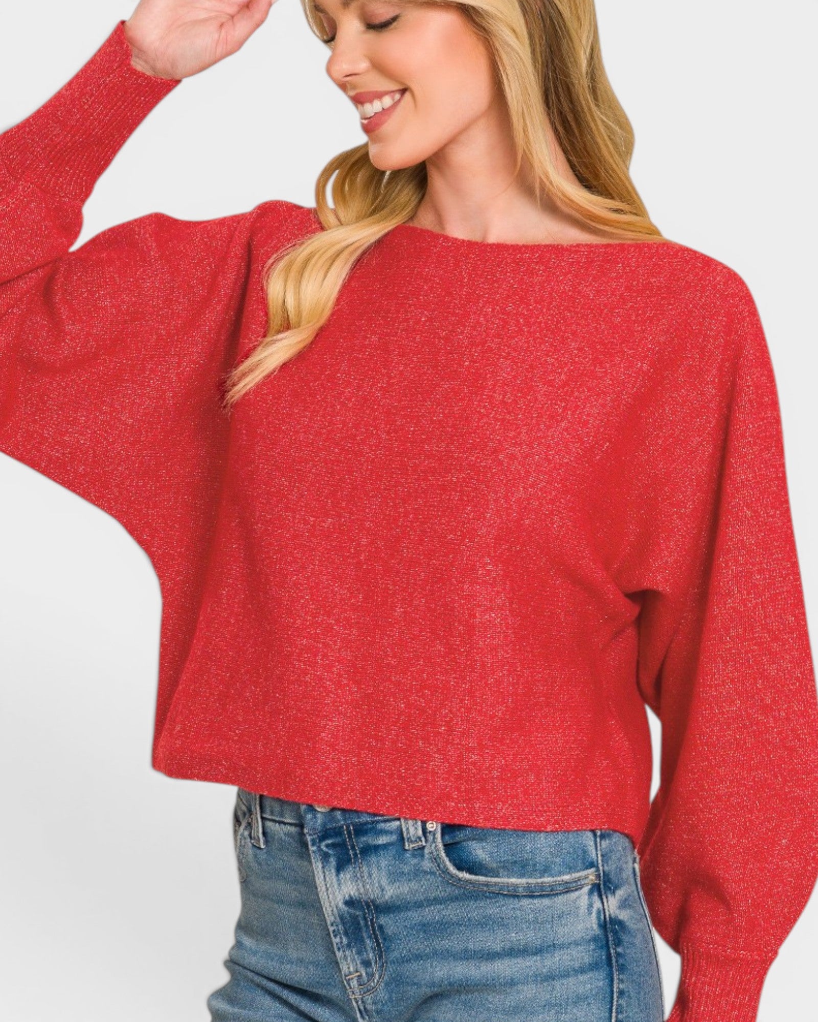 Woman wearing a red sweater and blue jeans on a white background