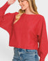 Woman wearing a red sweater and blue jeans on a white background