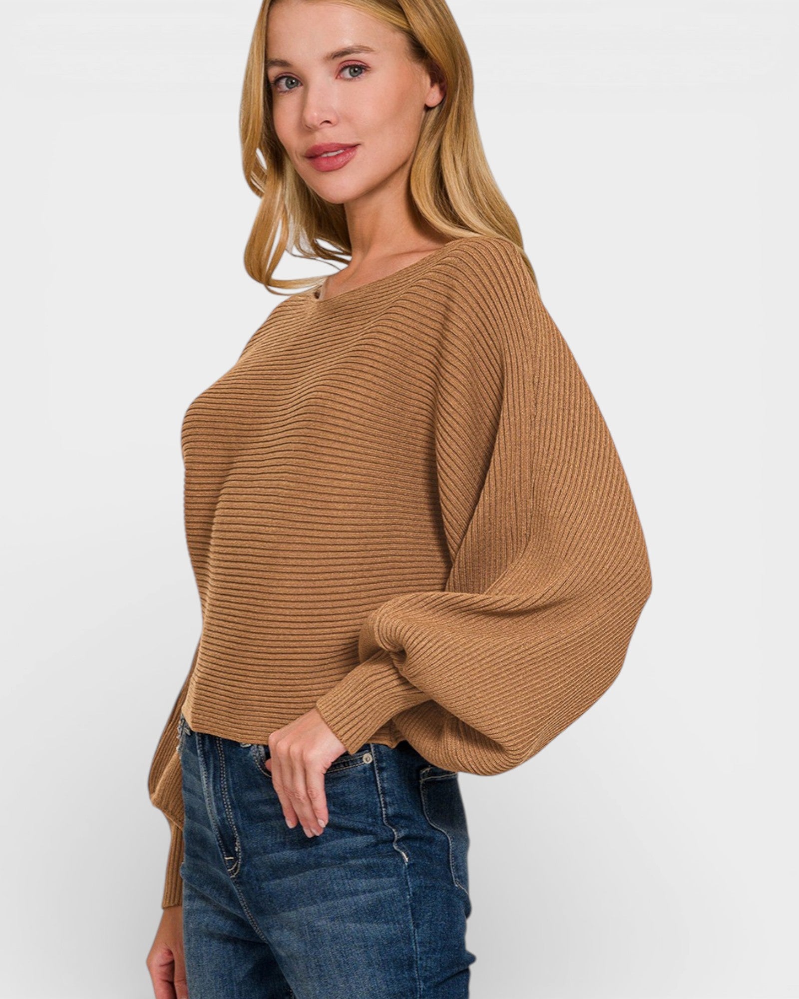 Woman wearing a brown sweater and blue jeans on a white background