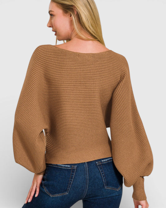 Woman wearing a brown ribbed sweater and blue jeans on a white background