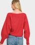 Person wearing a red sweater and blue jeans on a plain background